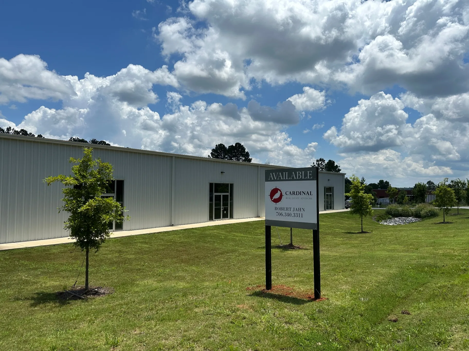 Metal-clad industrial manufacturing and assembly building exterior with Cardinal Real Estate Advisors signage